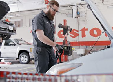Technician working under the hood of a vehicle.