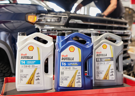 Car engine oil being poured into the top of an engine.