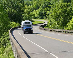 Truck hauling trailer along winding highway
