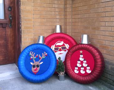 Finished holiday tire craft, used tires transformed into giant holiday ornaments, sitting on front porch