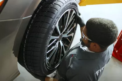 A technician performing a tire rotation.