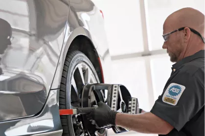Close up shot of a Firestone technician working on a tire.