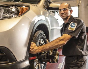 Tires Plus technician doing a wheel alignment