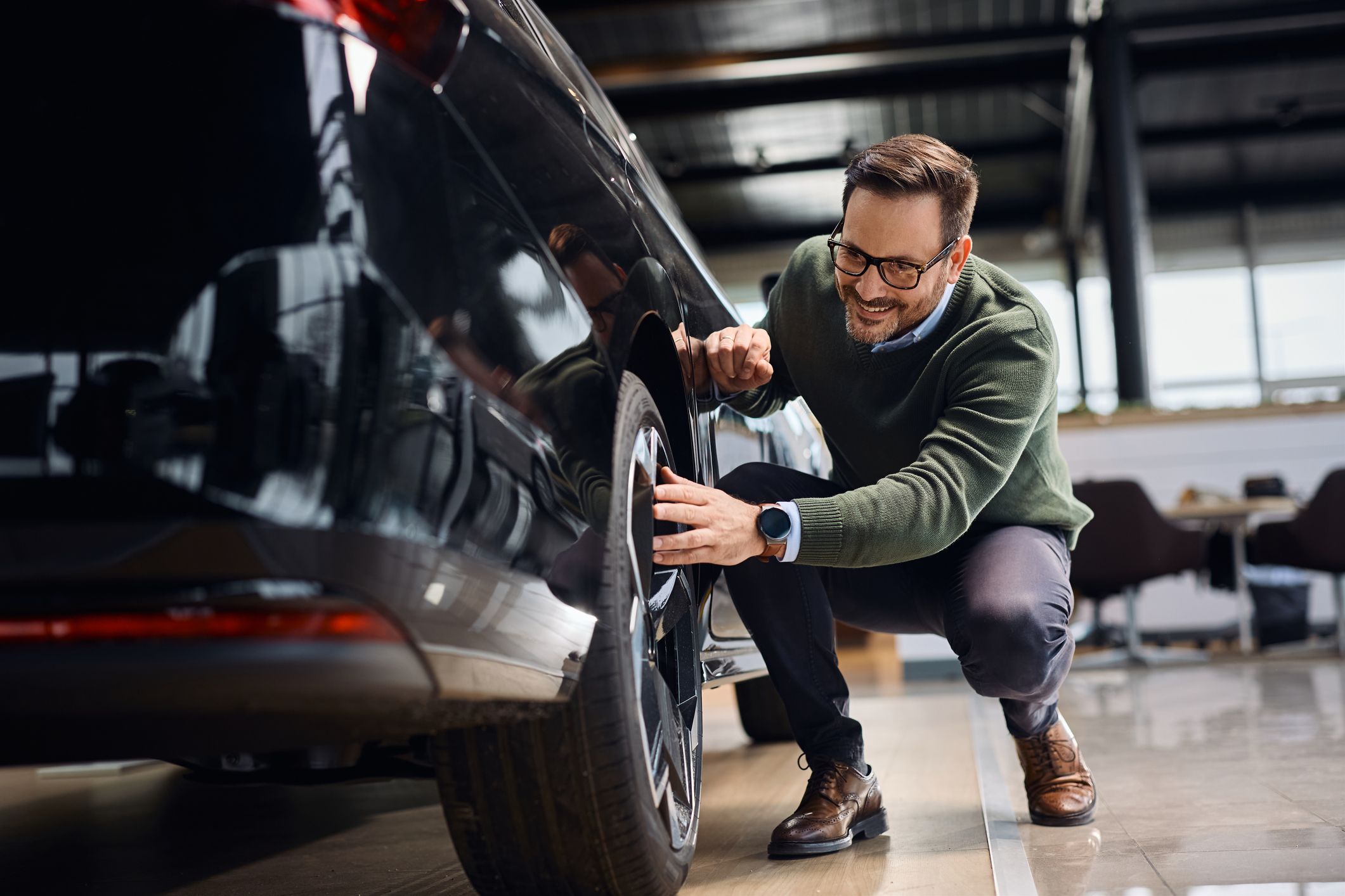 man examining tires on a car
