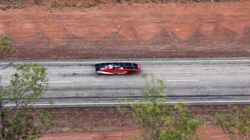 Red solar car on the highway