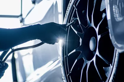 Closeup of a technician checking the tire pressure of a tire.