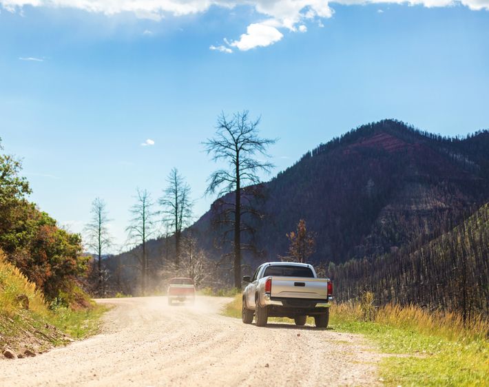 Pickup truck parked along dirt road on Western USA Road and in beautiful Mountain landscape near Durango Colorado