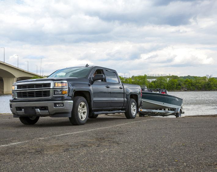 Truck pulling a boat from a lake