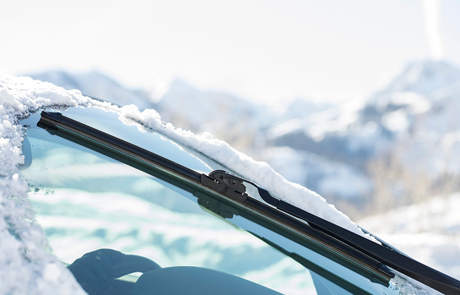 Windshield wiper clearing snow from a windshield.