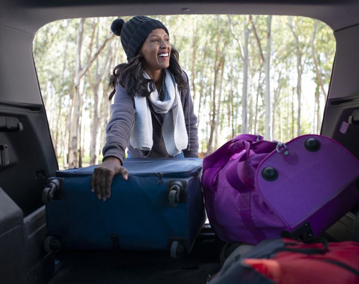 Woman loading luggage into a trunk