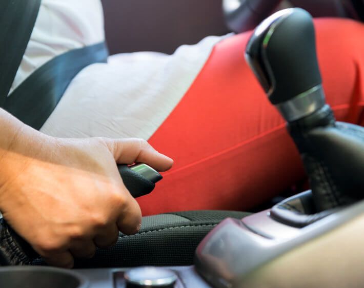 woman pulling her emergency brake