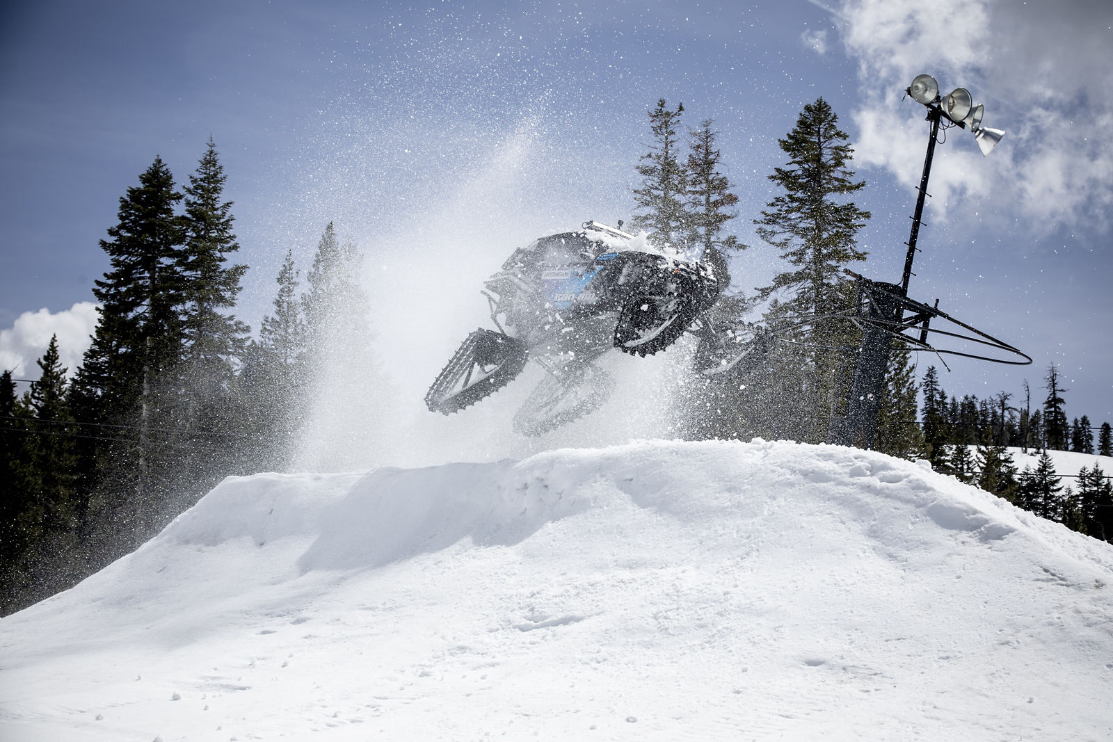 Ken Block riding a Can-Am Maverick X3 side-by-side with track system in a snow park