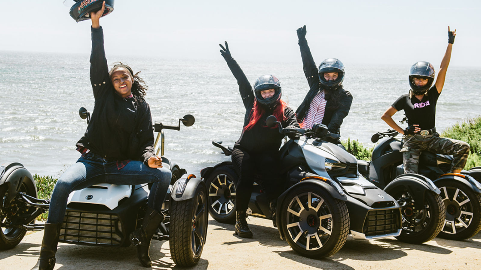 Women sitting on their Can-Am Ryker and raising their arm in the sky.