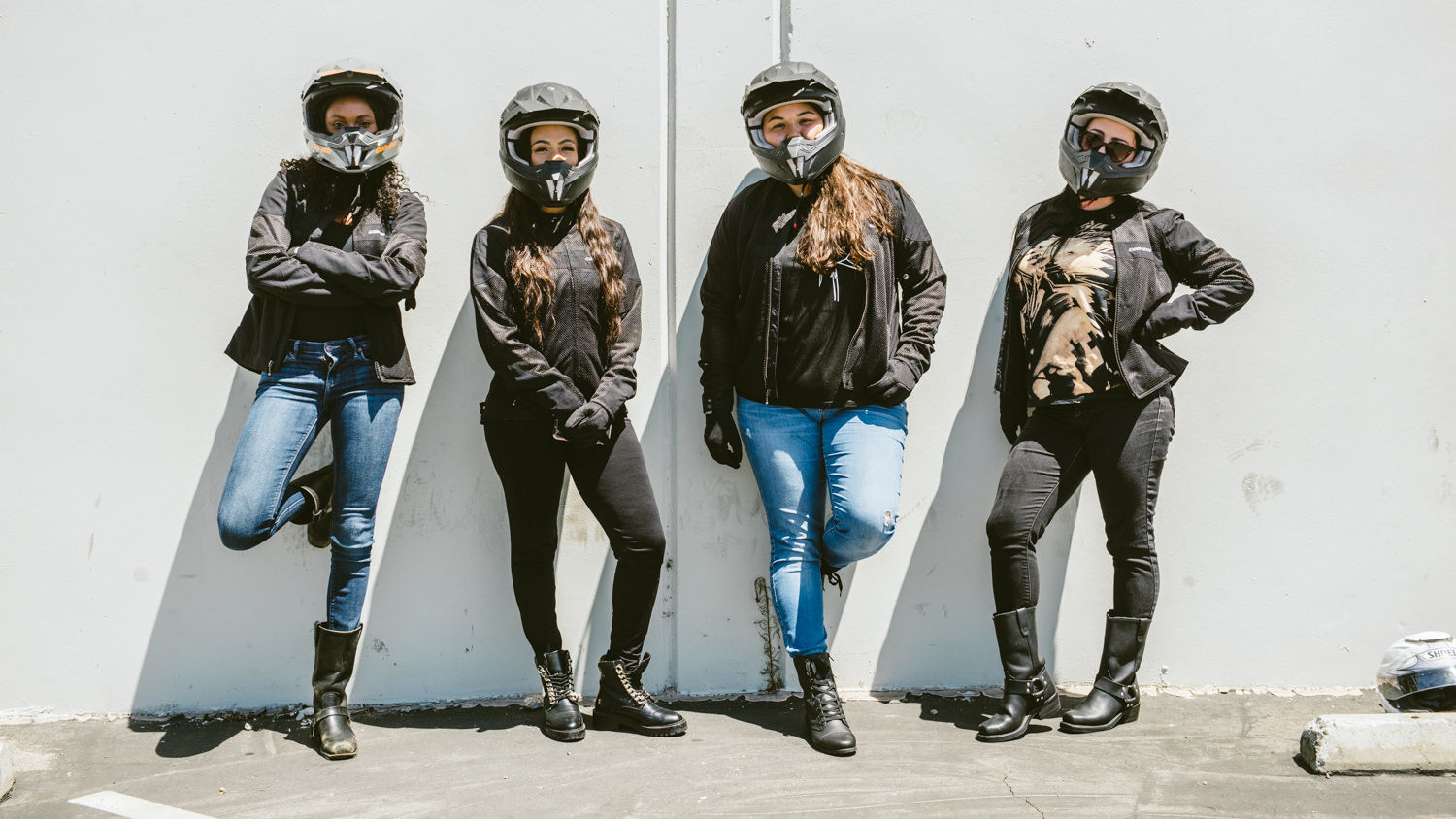 Four female riders with helmets posing