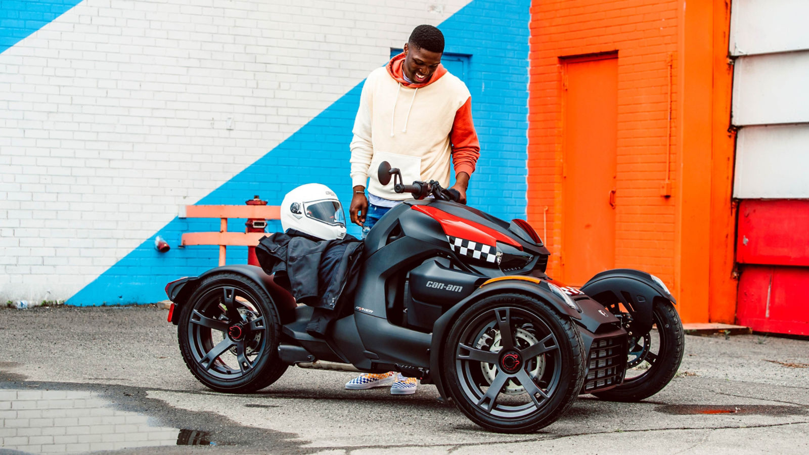 Man smiling with his Can-Am Ryker vehicle with racer red panels