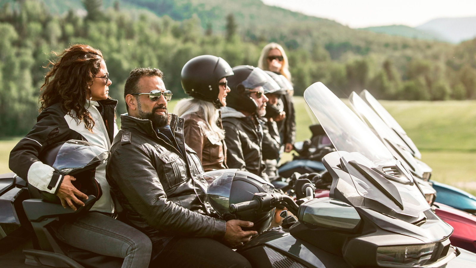 Grupo de pilotos sentados sus vehículos Can-Am Spyder RT
