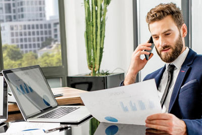 Man on the phone, reviewing a report