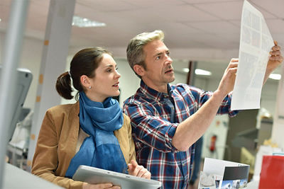 image of a man and woman looking at a print