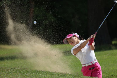 Woman swinging golf club