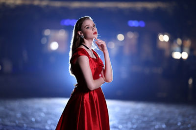 portrait of a woman in a red dress at night