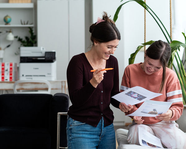 Deux filles souriantes et regardant du papier