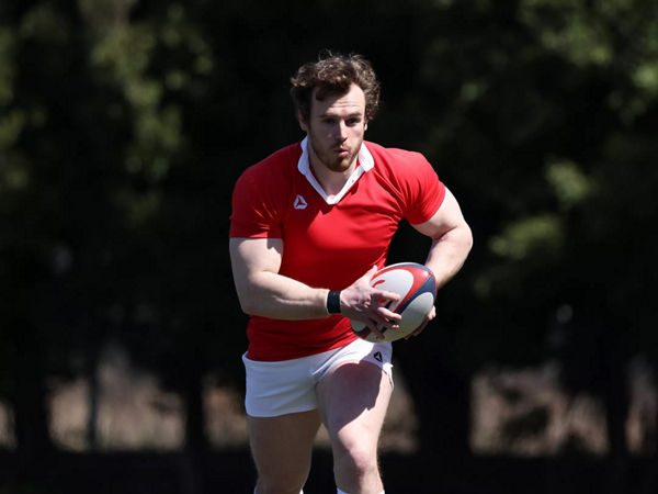 JouChien en basse lumièreeur de rugby courant vers la caméra