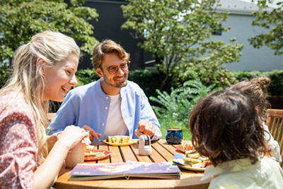 Family eating outdoor picnic at table