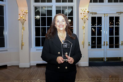 Amy Newman holding 2024 HERALD Top Chief Officers of Long Island Award