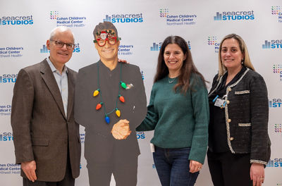 Cutout of Semour Liebman with Seymour and Jami on either side of the cutout with Sofia Agoritsas of Cohen Children's Medical Center