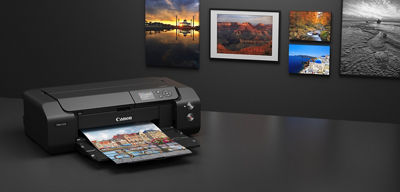imagePROGRAF PRO-310 with a photo output on a desk and photos displayed on wall behind it