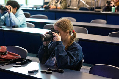 young student looks through canon camera viewfinder