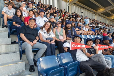 Canon executives join Townwide Fund of Huntington officials and children who received donated tickets to the Yankee game.