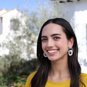 Personne souriant devant l’appartement en pierre blanche