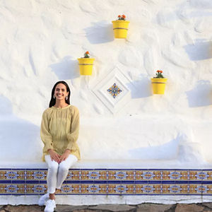Personne assise devant le mur de pierre blanche
