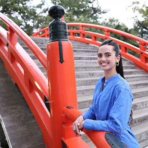 Personne en chemise bleue posant devant un pont