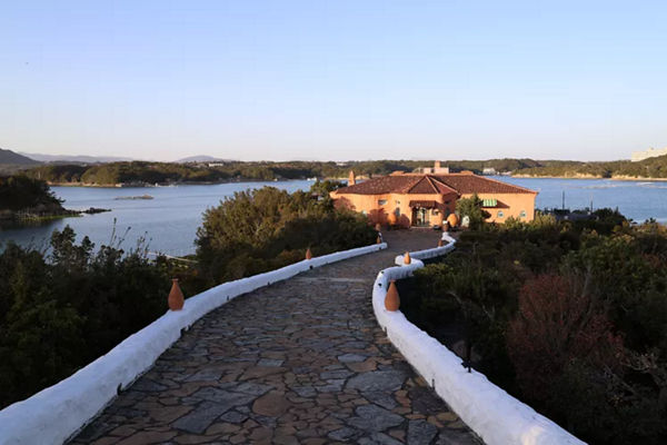Chemin de pierre menant à une maison près d’un lac