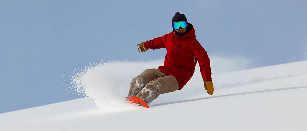 Une personne dévalant une pente enneigée en snowboard