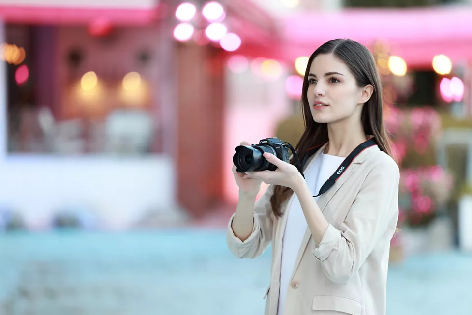 Person Holding the EOS R100 Ready to Take a Picture
