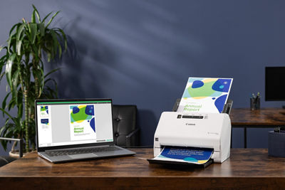 Canon Scanner Next to a Laptop on an Office Table