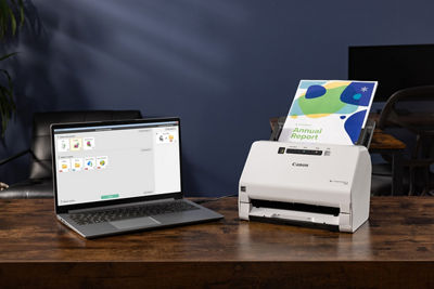 Canon Scanner Next to a Laptop on an Office Table