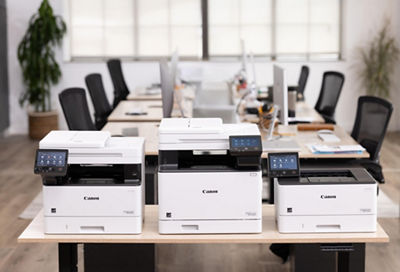 Different Laser Canon Printers on a Wooden Table