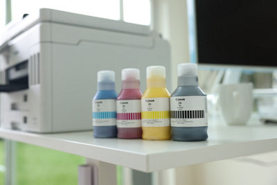 Ink Bottles Next to Canon Printer