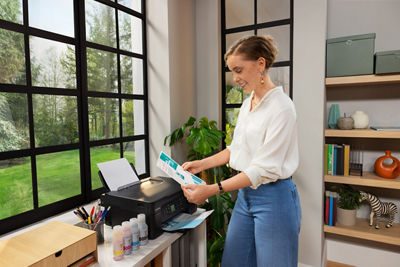 Person Getting Printed Paper From Canon Printer