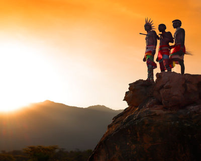people on cliff during sunset