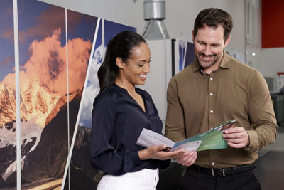Man and a woman reviewing a printed piece