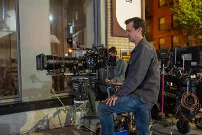 man standing behind cinema camera