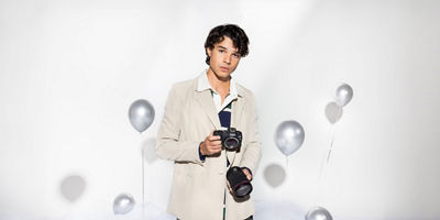 Man holding a camera and lens