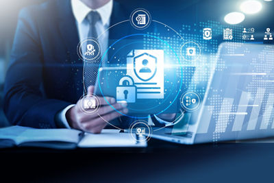 Man at desk looking at tablet and laptop