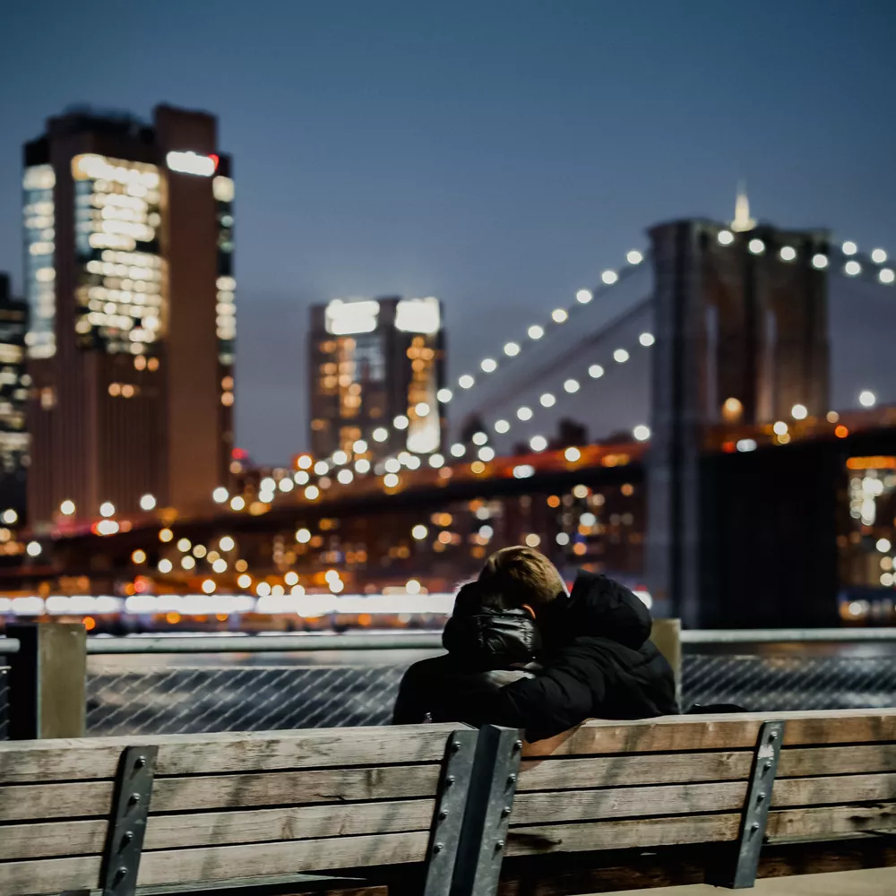 Couple on a bench with bridge in background