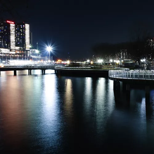 Night image of walking bridge and cityscape